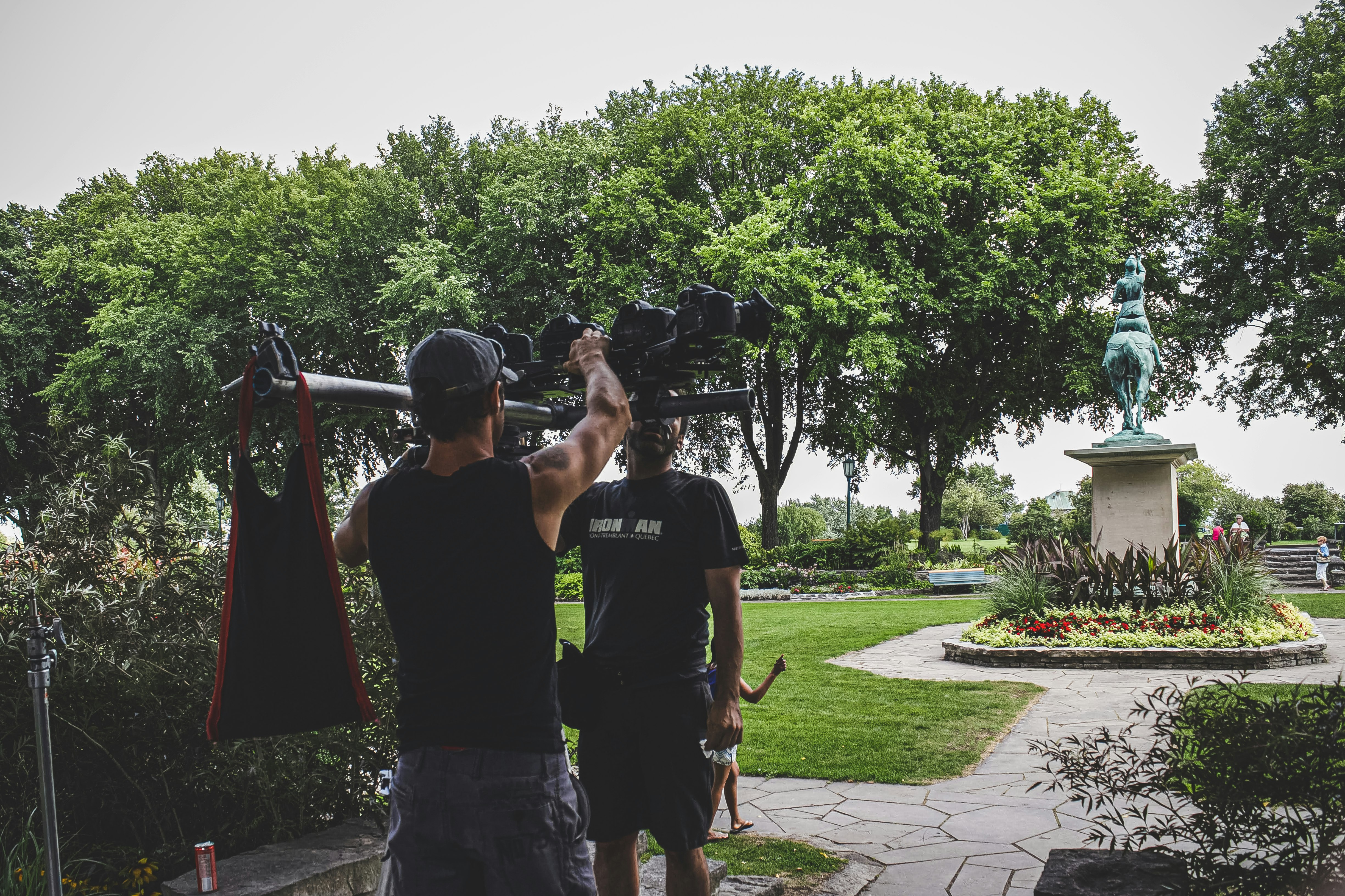 man in black crew neck t-shirt standing near green trees during daytime